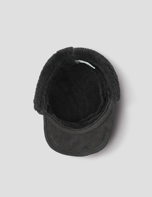 Black curly merino shearling press stud cap with peak. Inside flat lay view.