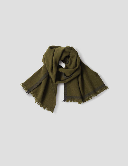 Green knitted scarf with fringe and dark green contrast edge. Front flat lay view.