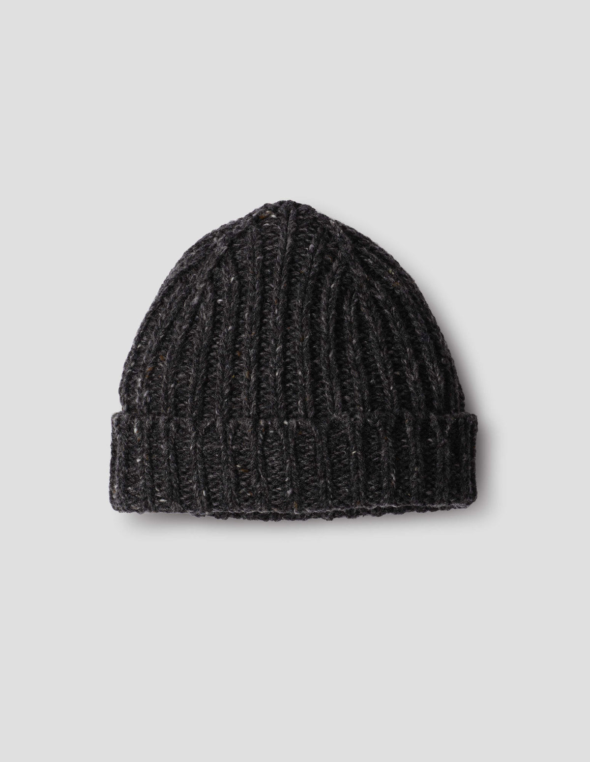 Dark grey chunky ribbed donegal lambswool mix knitted beanie with light contrasting flecks and turn up brim. Front flat lay view.