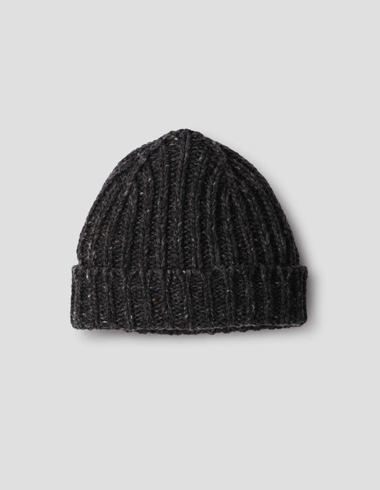 Dark grey chunky ribbed donegal lambswool mix knitted beanie with light contrasting flecks and turn up brim. Front flat lay view.