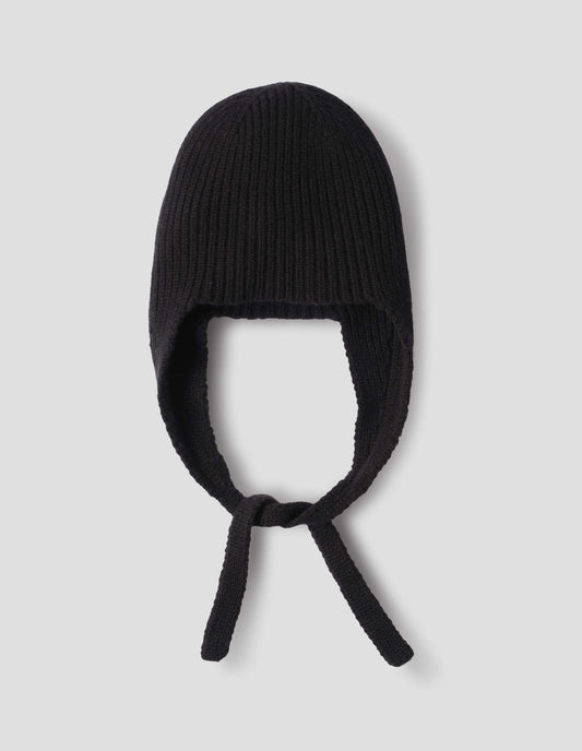 Black soft spun merino knitted ribbed hat with ear flaps and tie detail. Front flat lay view.