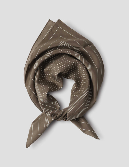 Khaki green folded and tied silk neck scarf with white stripes and dots, and hand rolled edges. Close up flat lay view.