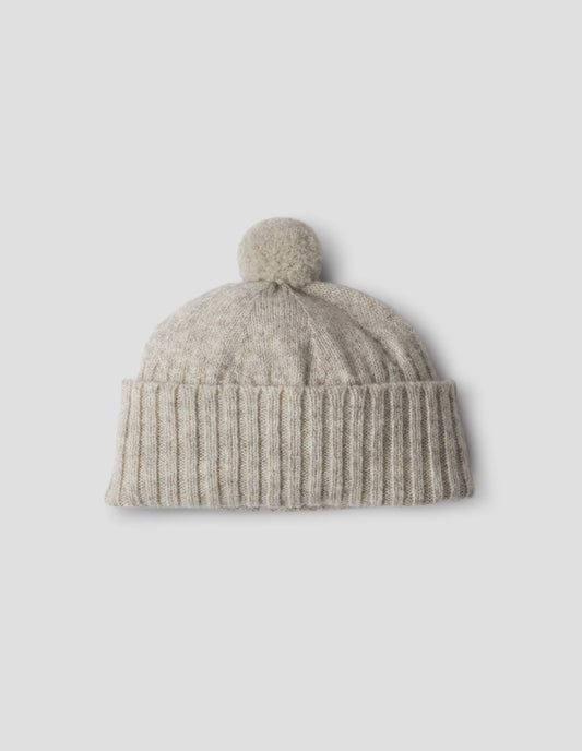 Beige knitted Shetland wool bobble hat with rib turned up cuff, front flat lay view.