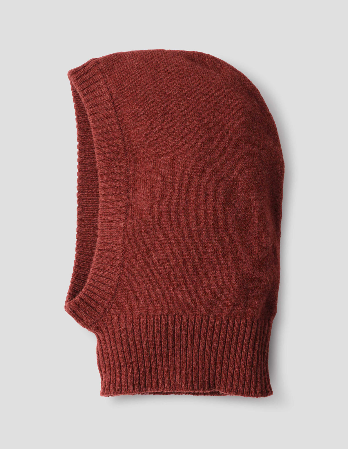 Brownish orange felted knit lambswool hood with contrasting rib on face and neck, side flat lay view.