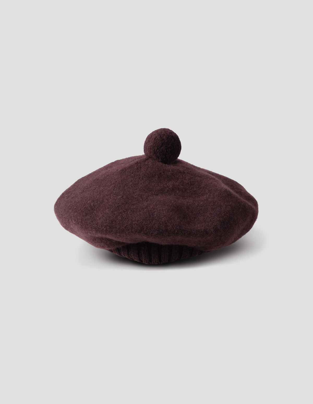 Dark brown wool tam o shanter hat with matching pom pom in centre, side view.