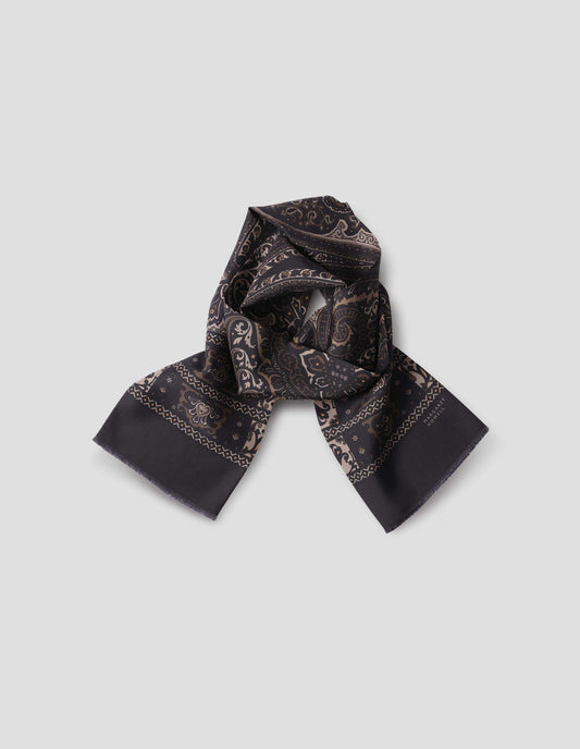 Dark blue double sided silk scarf with light and dark beige paisley print, frayed edges and contrast Margaret Howell logo on right. Front flat lay view.