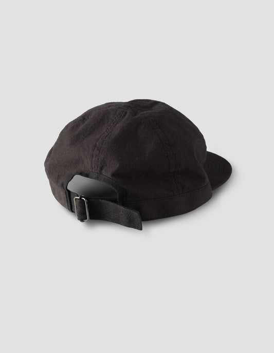 Black soft peak cap with contrast herringbone tape slide adjustor detailing. Back view flat lay.