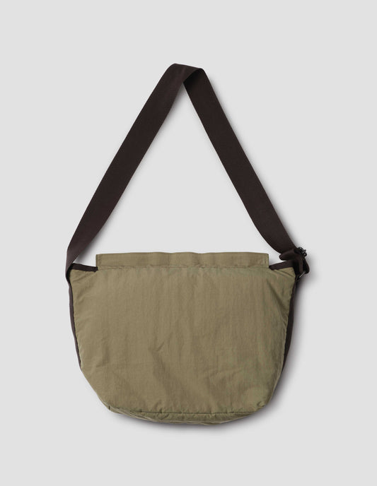 Khaki green bag with contrast black herringbone tape shoulder strap and Velcro closure. Back flat lay view. 