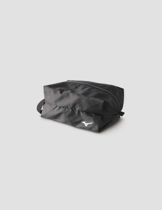 Black nylon ripstop small pouch with zip closure and contrasting white Mizuno logo on front. Side flat lay view.