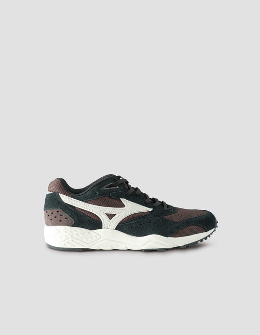 A single black and dark brown suede trainer with mesh insert and off white sole, with off white Mizuno logo running through the side. Side view flat lay.