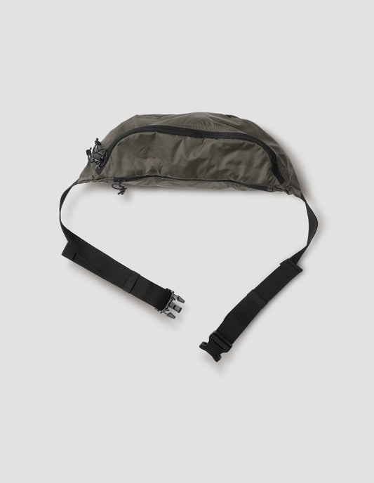 Khaki green nylon ripstop waist pouch with contrasting black adjustable strap and contrast black zip closure. View from above flat lay.