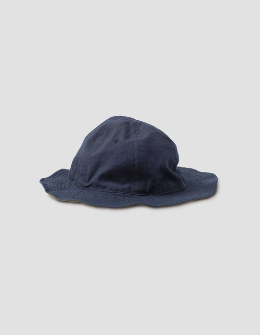 Dark blue cotton hat showcasing the flexible reversible design. Side view.