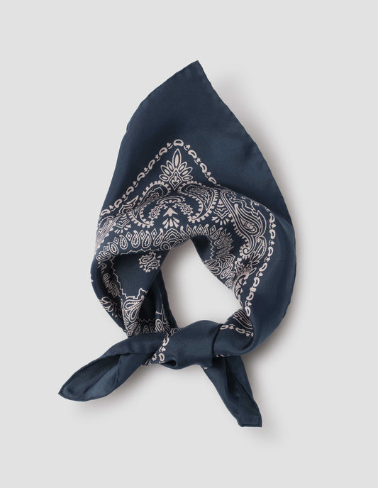 Navy blue square neck scarf with contrast white paisley pattern, styled knotted. Front flat lay view.