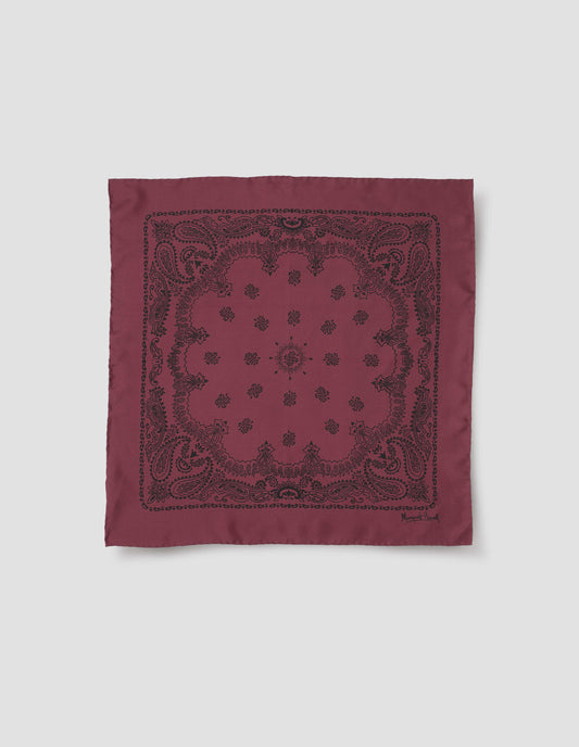 Dark pinkish red square neck scarf with contrast black paisley pattern and Margaret Howell signature in bottom right corner. Front flat lay view.