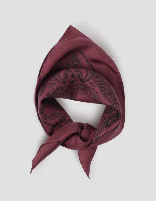 Dark pinkish red square neck scarf with contrast black paisley pattern, styled knotted. Front flat lay view.