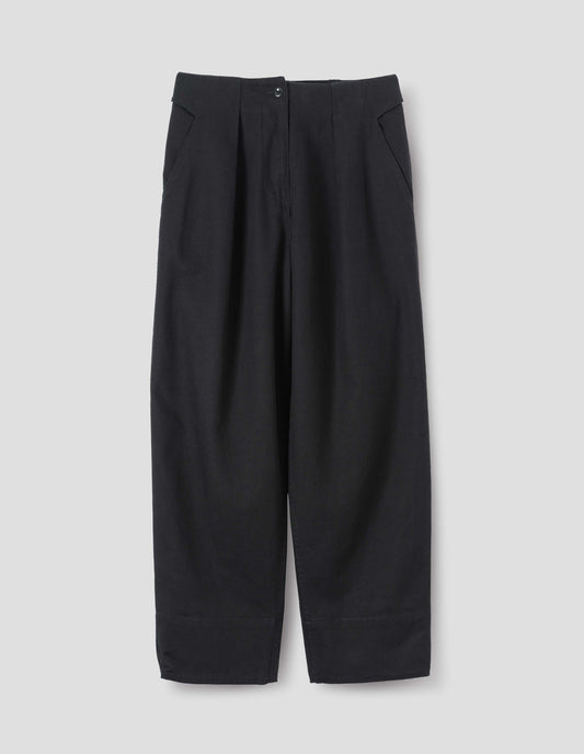 Black cotton wool trousers, with zip fly and corozo brace button fastening, self waistband detail, slant pockets, front pleats and deep stitch hem. Front flat lay view.