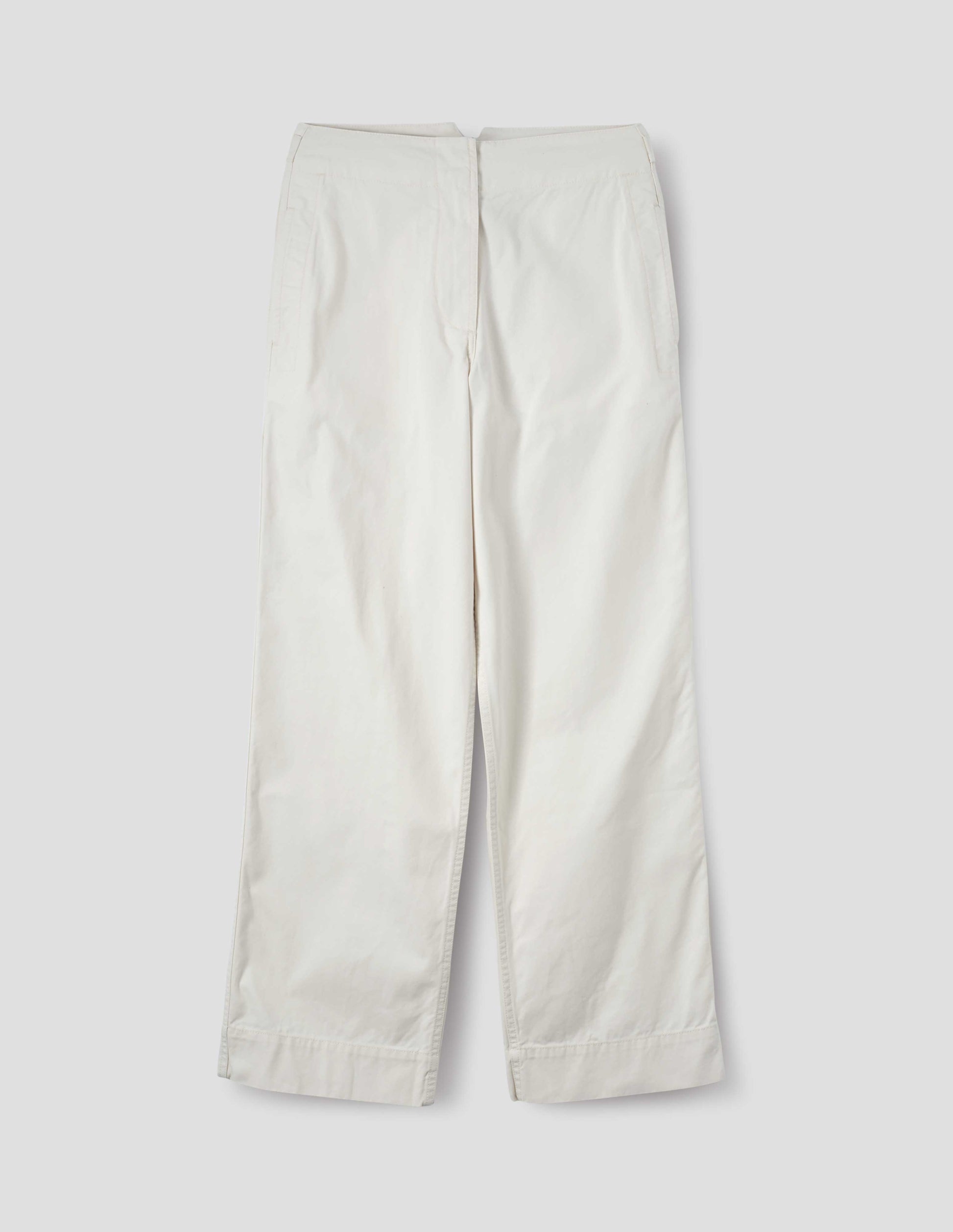 Off white cotton trousers with zip fly with button through fastening, stitch through waistband, and concealed side pockets. Front flat lay view.