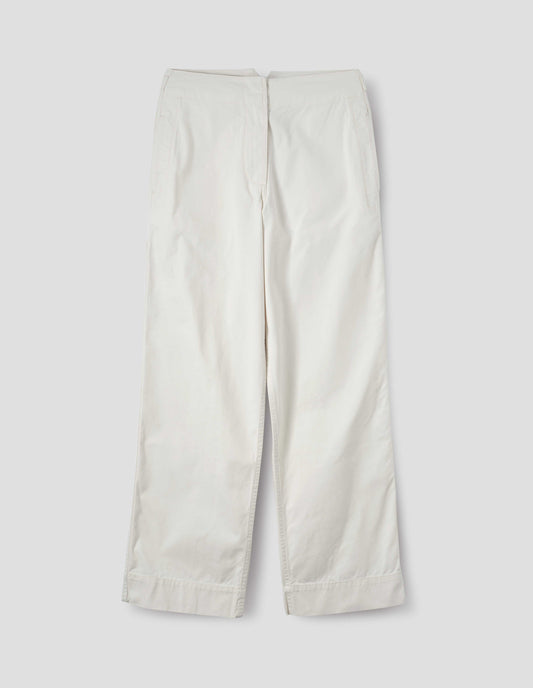 Off white cotton trousers with zip fly with button through fastening, stitch through waistband, and concealed side pockets. Front flat lay view.