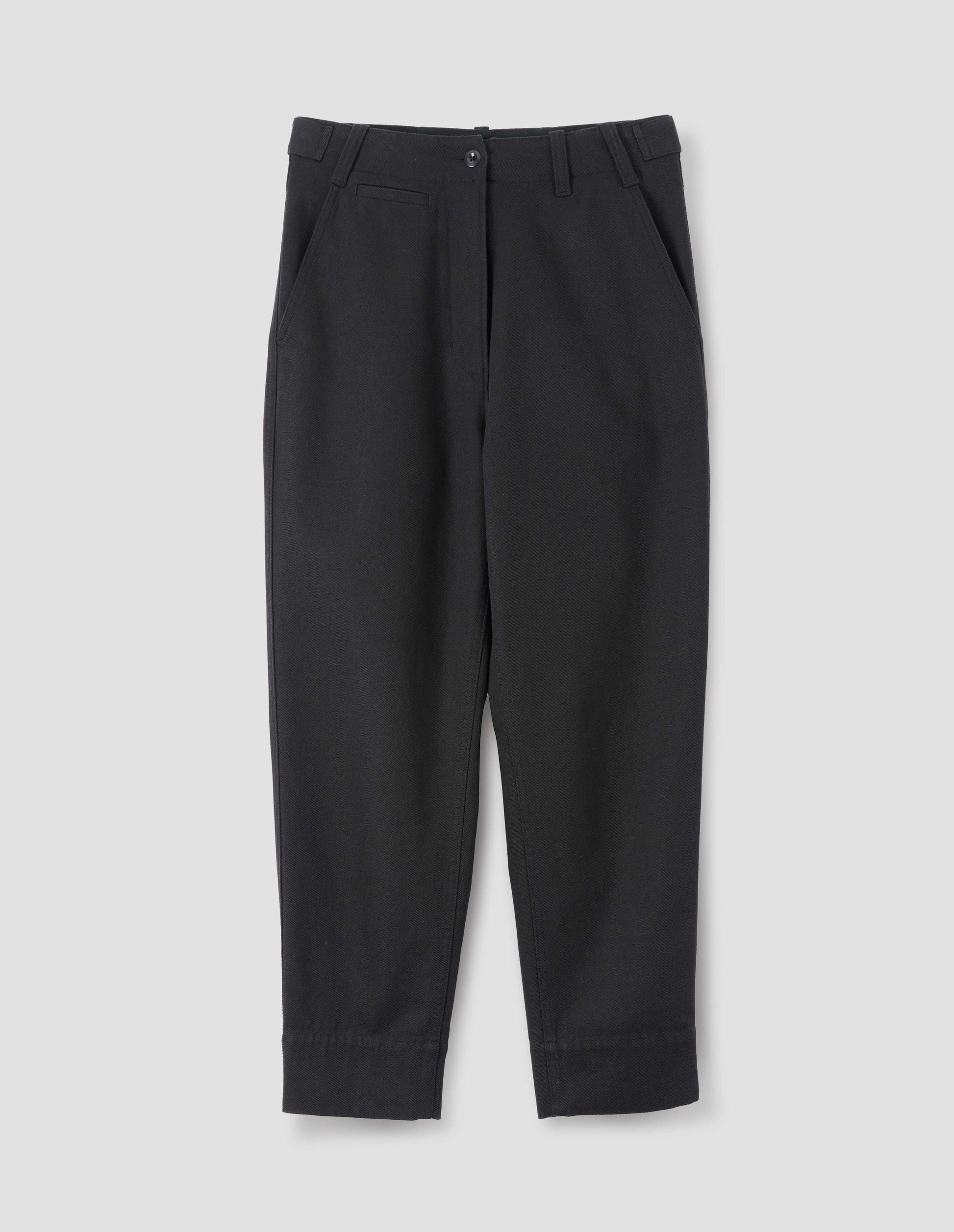 Black cotton wool trousers with zip fly button through fastening, button tab side adjusters, belt loops, slant pockets and ticket pocket detail. Front flat lay view.
