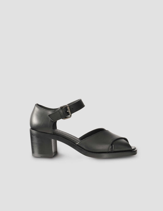 A single black leather open toe heels with buckle fastening. Side view flat lay.