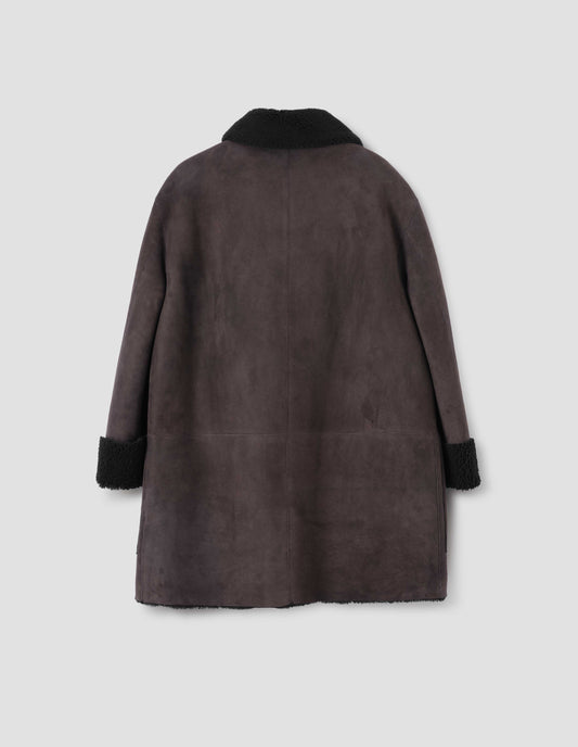 Brown and black merino sheepskin car coat with contrast sleeves and collar. Back flat lay view.
