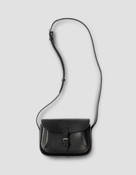 Black fine grain leather small satchel bag with pleat expandable exterior pocket, roller buckle fastening closure and adjustable shoulder strap. Front flat lay view. 