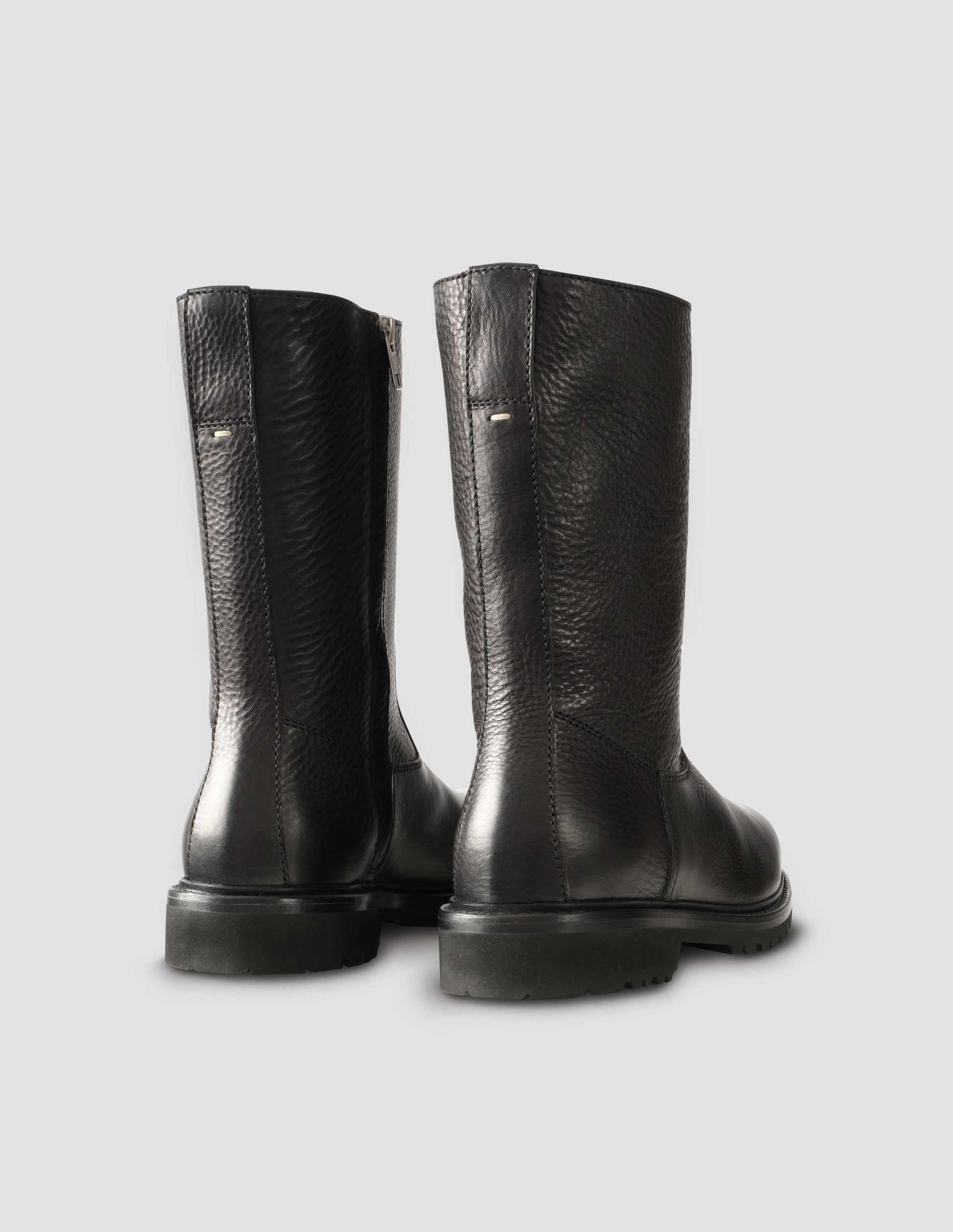 Black leather three quarter length boots with Vibram sole and shearling lining. Back view flat lay.