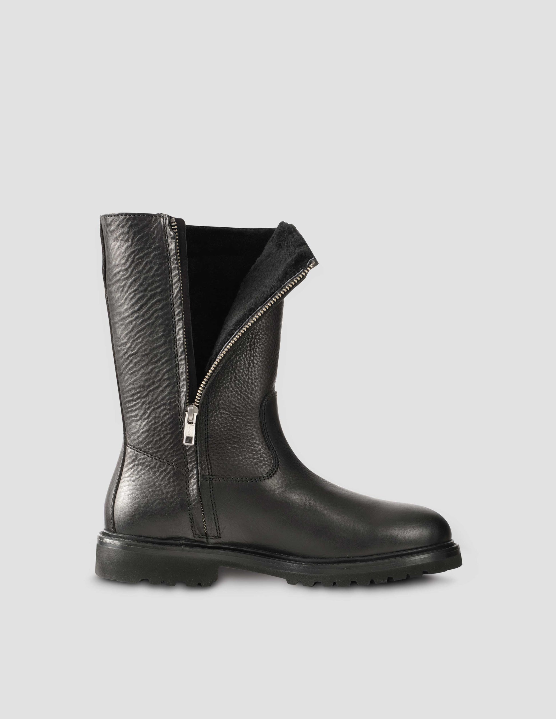 Black leather three quarter length boot with side zip, Vibram sole and shearling lining. Side view to display zip undone flat lay.
