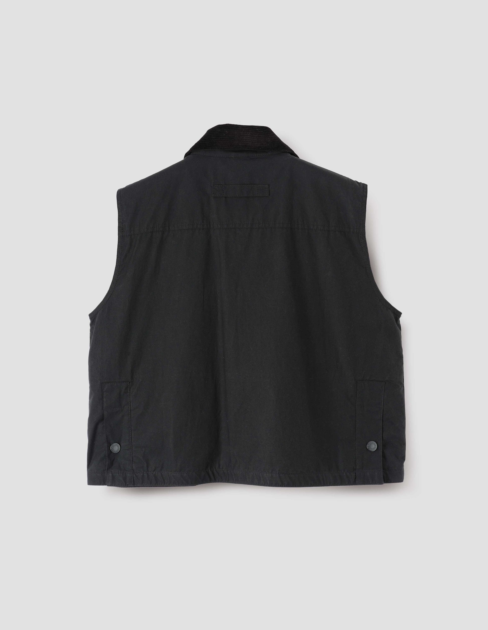 Black boxy gilet with corduroy collar, hanger loop and press stud fastening vent split hem with gussets. Back flat lay view.