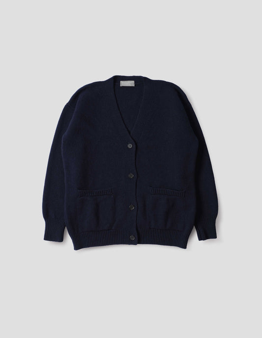 Navy blue v-neck cardigan, with contrast rib on placket, cuffs and hem and two front pockets, finished with horn button closure. Front flat lay view.