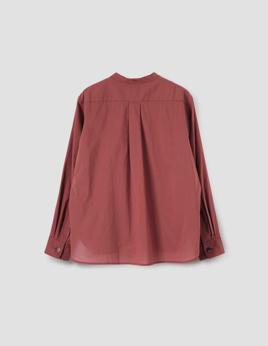Red pink collarless shirt with box pleat back yoke, elongated hem and horn button cuffs, back flat lay view.