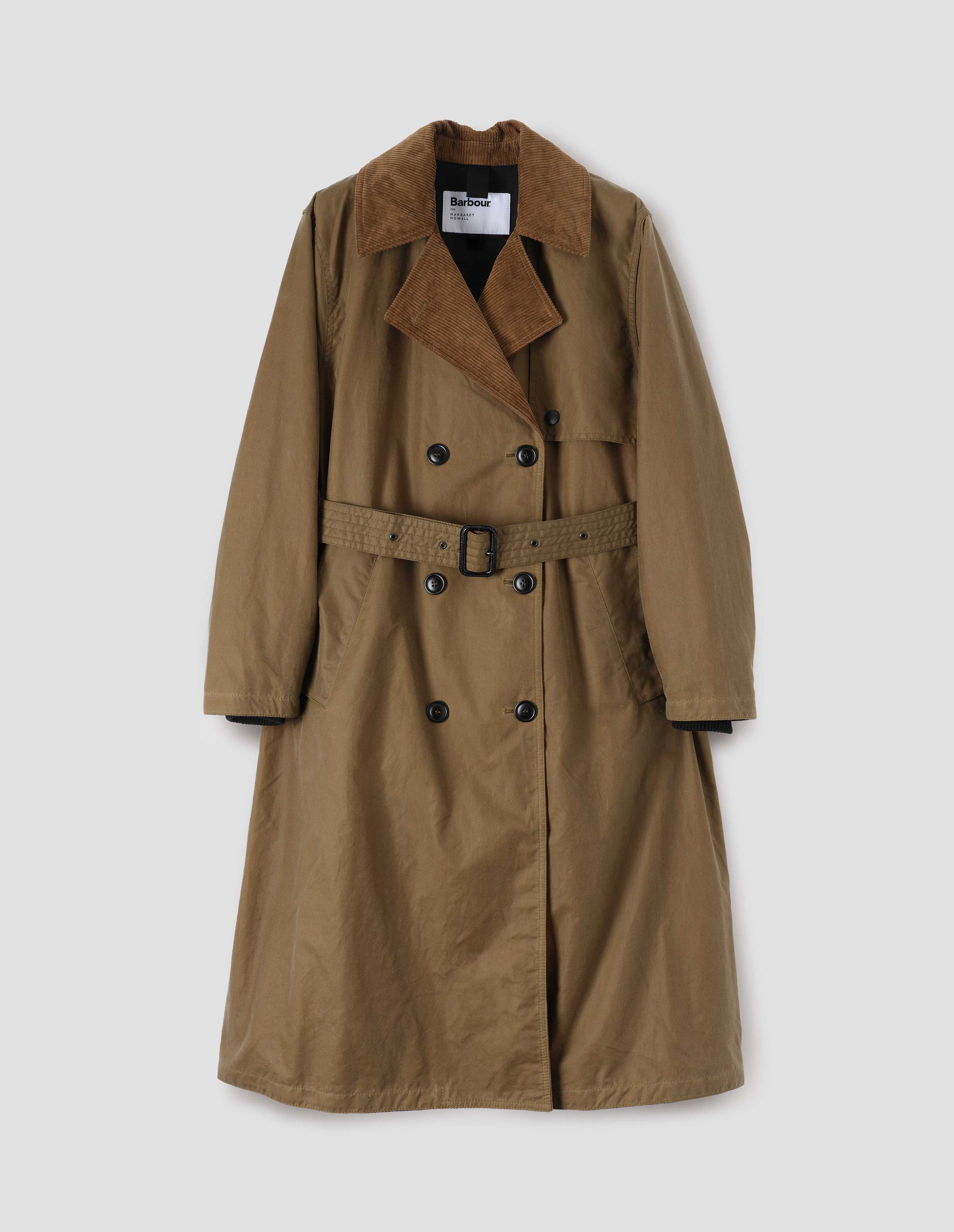 Light brown trench coat with corduroy collar and lapel, press stud fastening storm flap, horn buttons, leather buckle belt and deep welt slant pockets. Front flat lay view.
