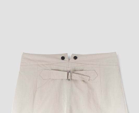Beige high waisted trousers with double black horn button details on waistband and cinch back, back flat lay view. 