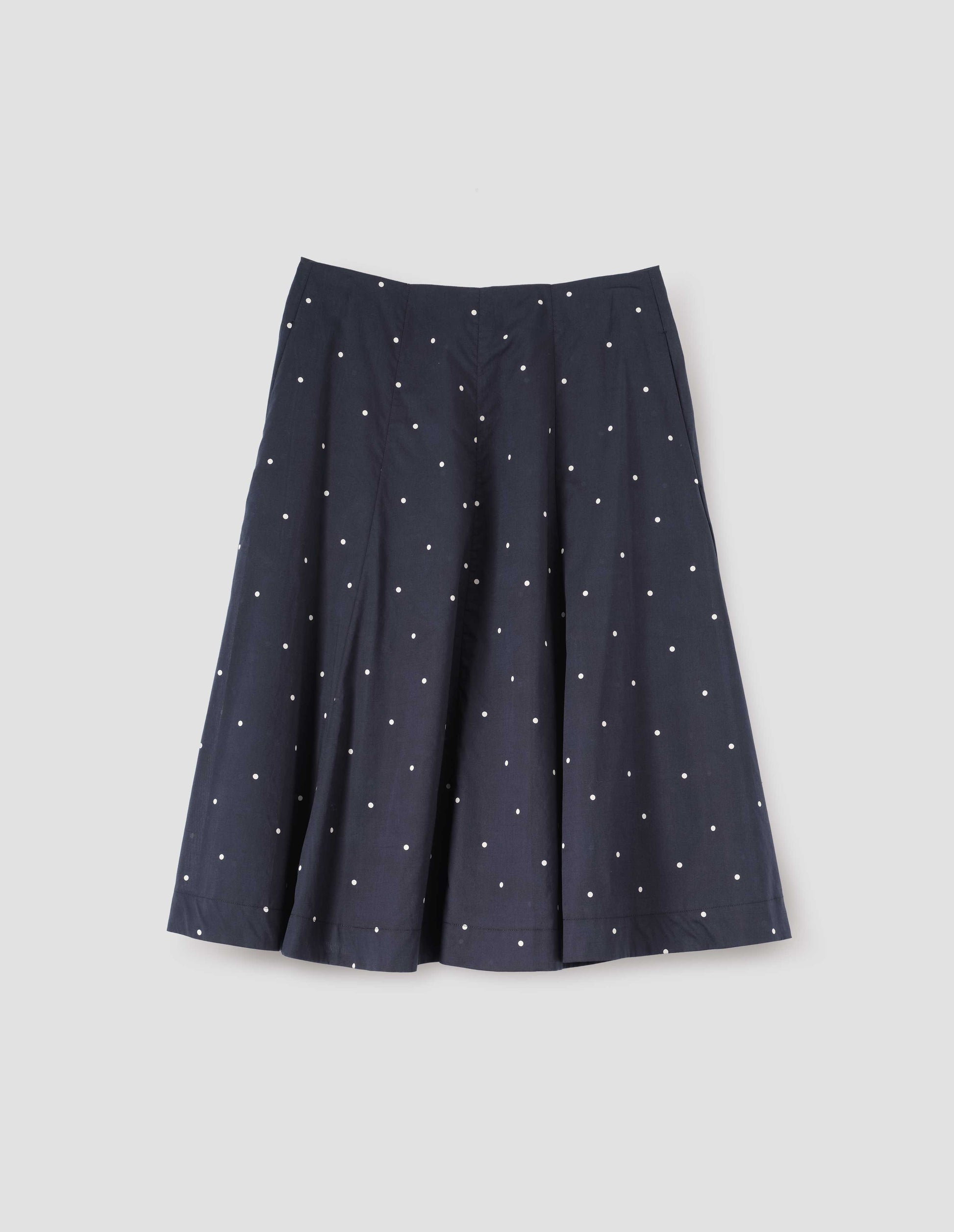 Navy blue and white polka dot flared skirt, with concealed side pockets. Front flat lay view.
