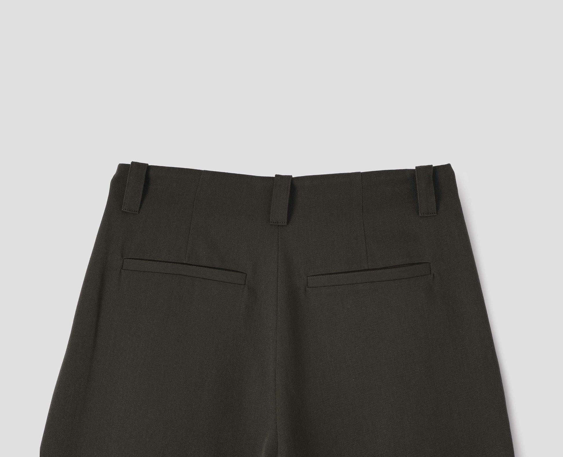 Brownish green wool wide leg culottes, with belt loops, side pockets and welt back pockets. Back flat lay view.
