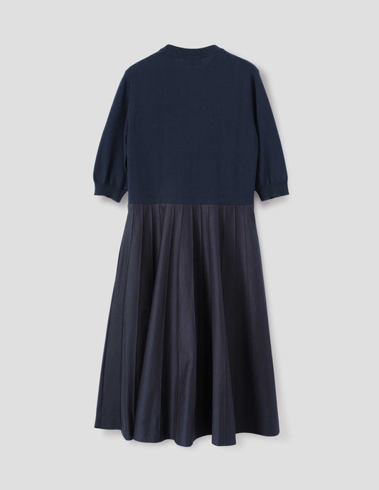 Navy blue short sleeve knitted and silk dress. Knitted merino wool top and cotton silk skirt. With concealed side pockets and pintuck detailing on skirt. Back flat lay view.