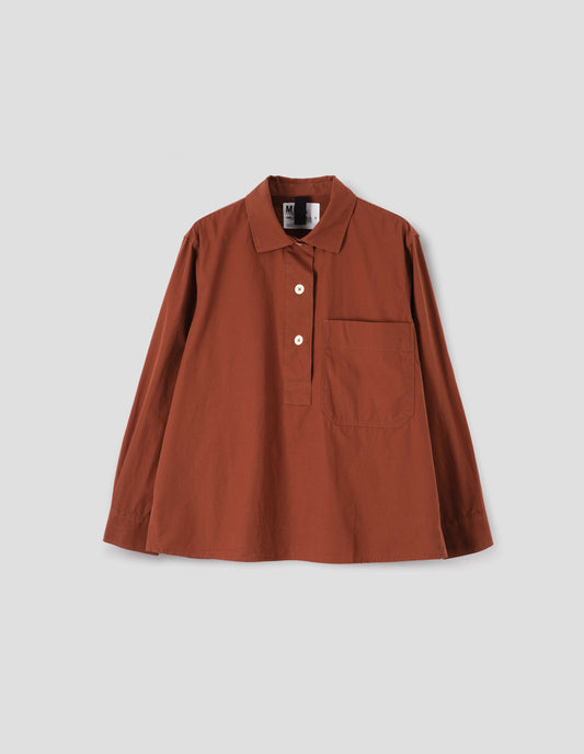 Brownish red shirt with half placket, large chest pocket and corozo button cuffs. Front flat lay view.