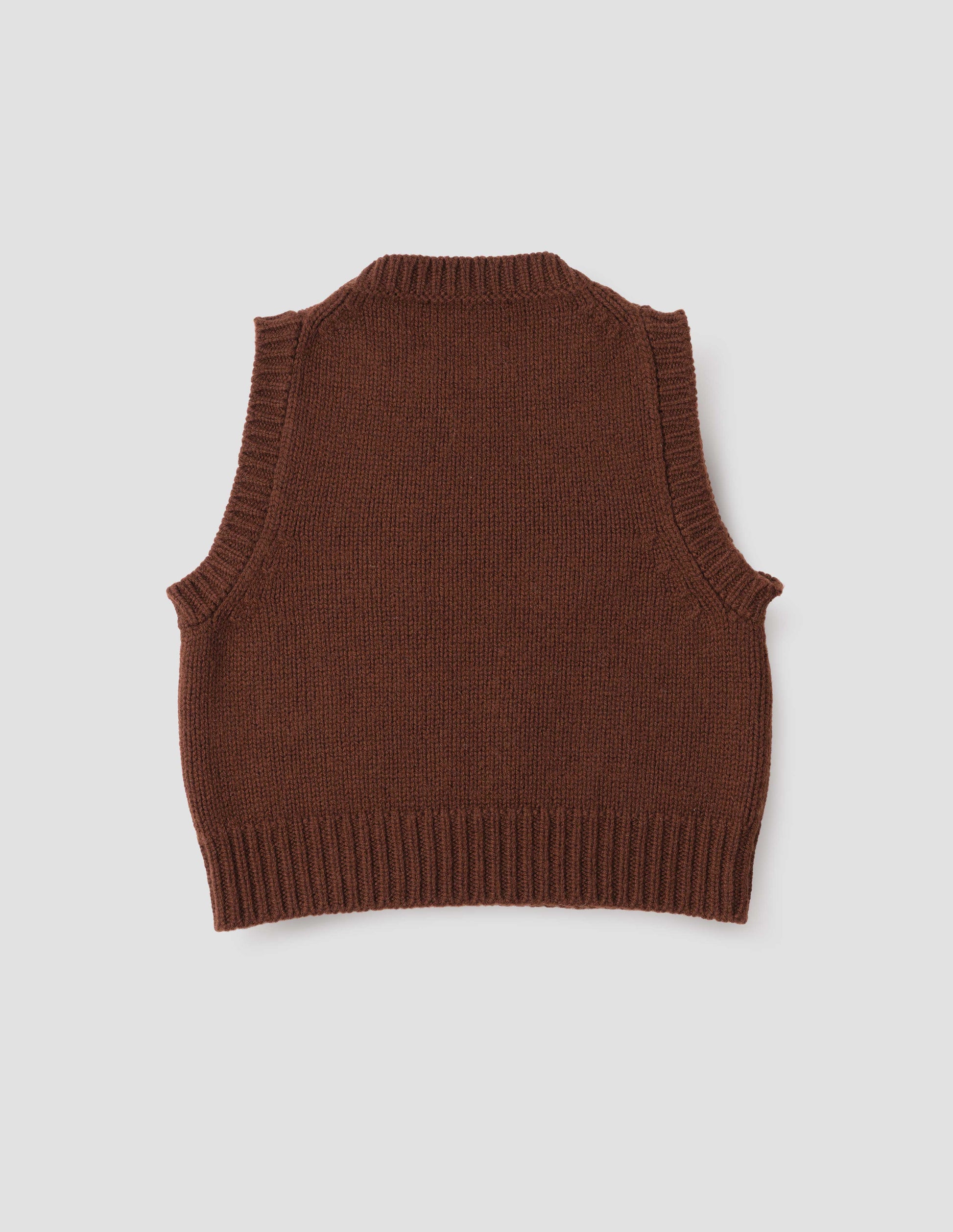 Red brown sleeveless knitted vest with contrasting neckline, hem and deep armholes. Back flat lay view.