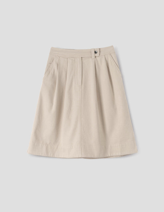 Beige A-line skirt with pleats, denim button fastening and zip fly, slant pockets with ticket pocket detail, front flat lay view.