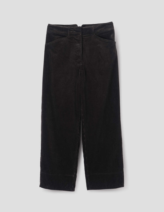 Black heavy corduroy trousers with concealed double hook and bar fastening, frog pockets and deep stitch-through hem. Front flat lay view.