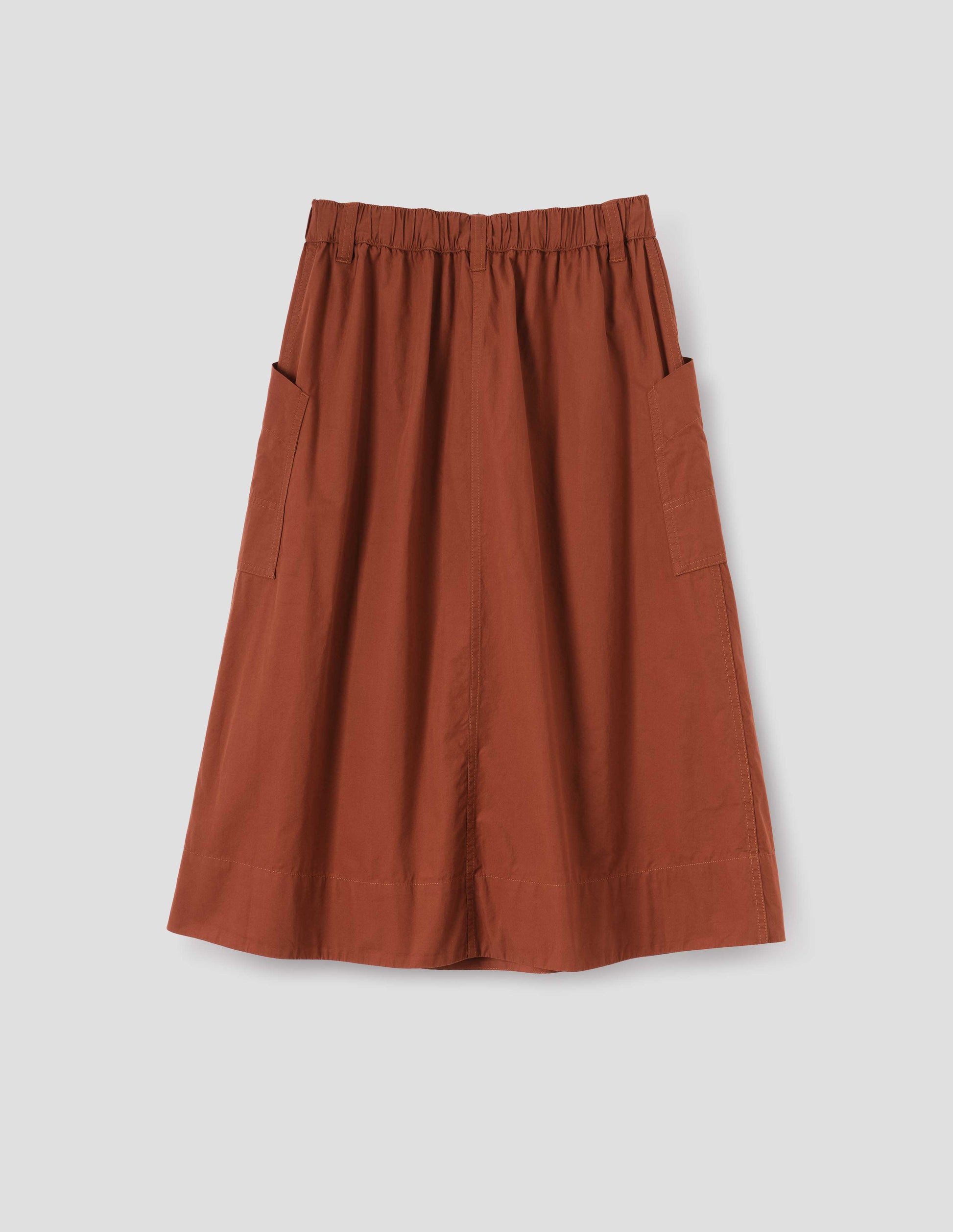 Dark orange A-line skirt with elasticated waist, belt loops and large, slant side patch pockets with reinforced stitch detailing, back flat lay view.