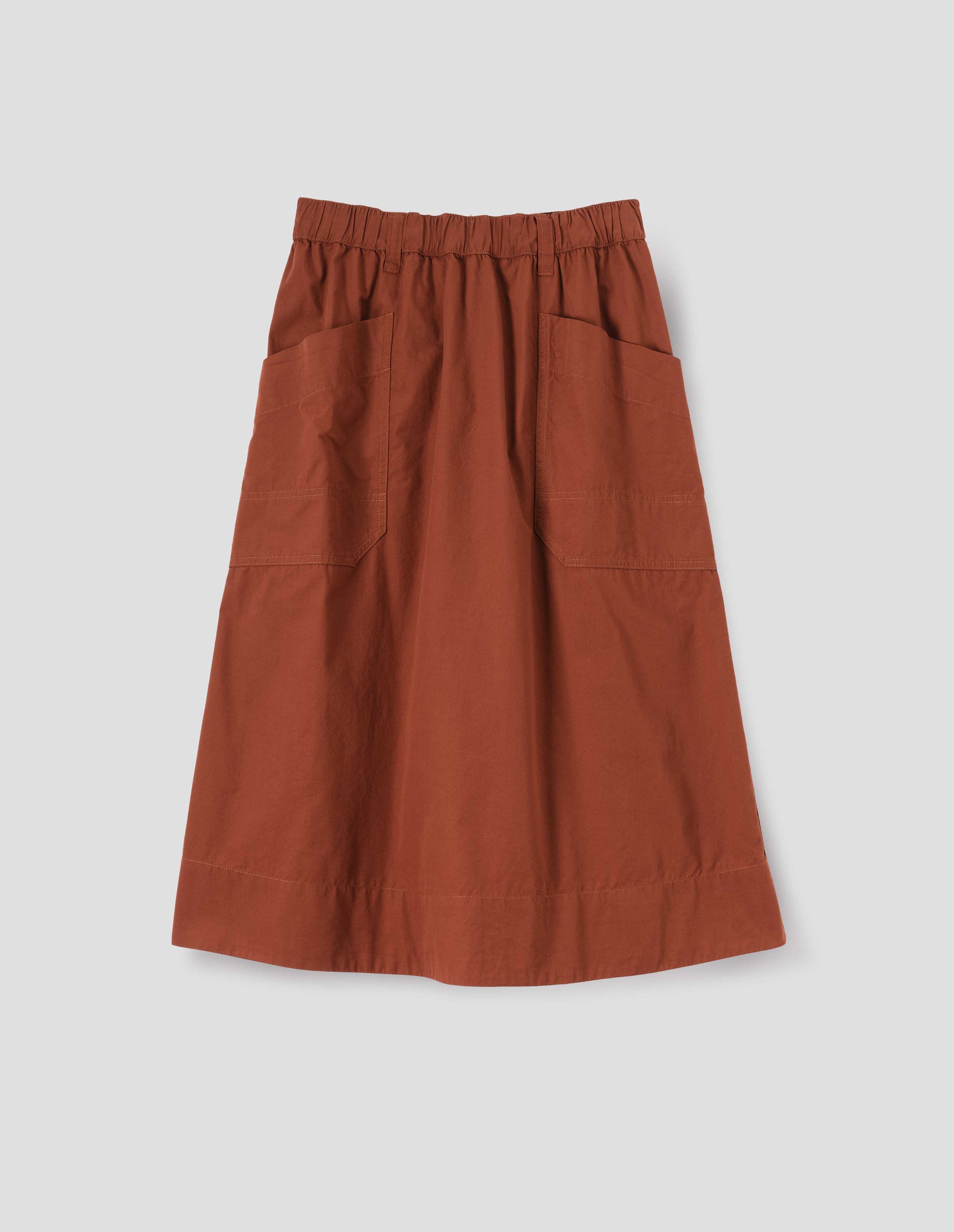 Dark orange A-line skirt with elasticated waist, belt loops and large, slant patch pockets with reinforced stitch detailing, front flat lay view.