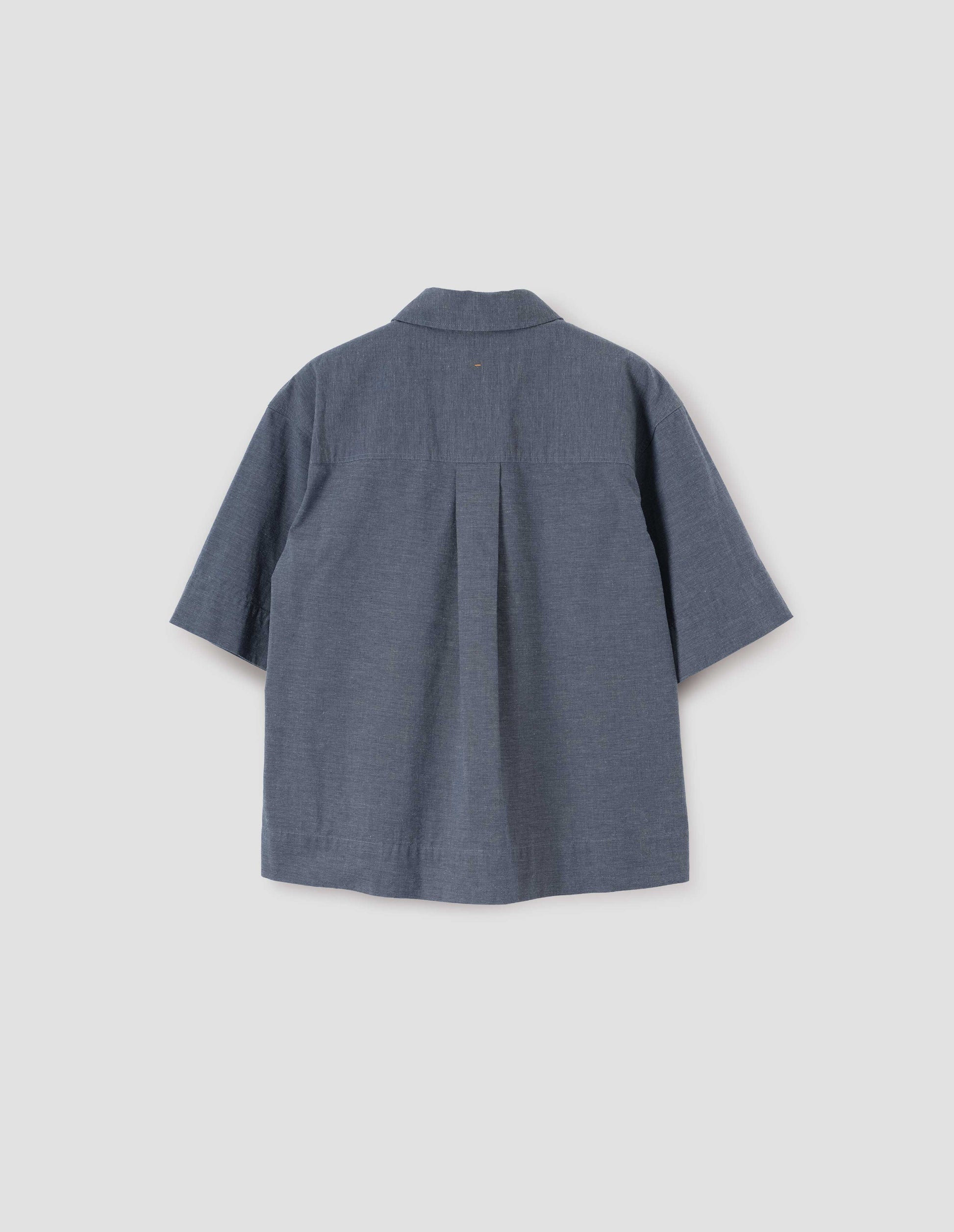 Greyish blue short sleeve shirt, with elbow length sleeves, and box pleat on back yoke. Back flat lay view.