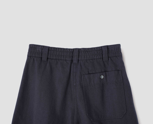 Dark navy culottes, with half elasticated waist, belt loops and press stud patch back pocket, back flat lay view.