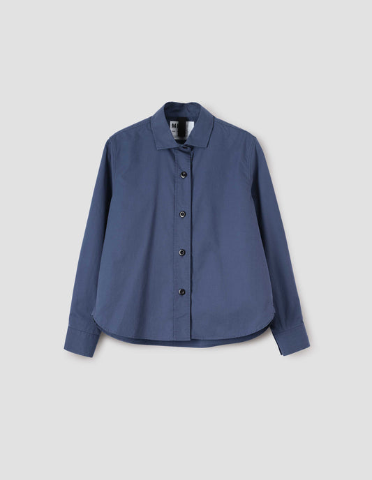 Indigo blue long sleeve shirt, with stitch through raised placket, corozo button closure and cuffs and curved hem, front flat lay view. 