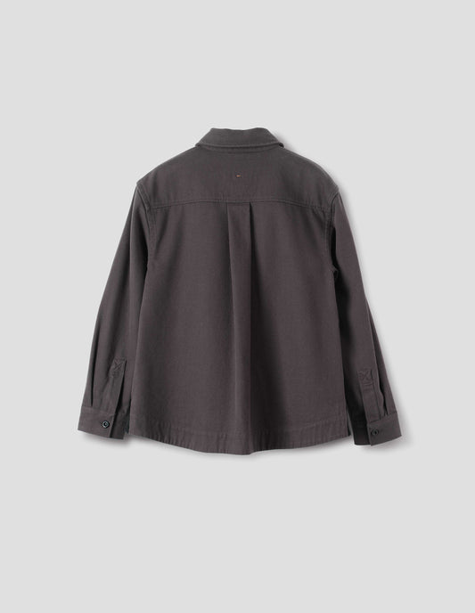 Grey oversized shirt with corozo button fastening cuffs, box pleat on back yoke and deep stitch hem. Back flat lay view. 