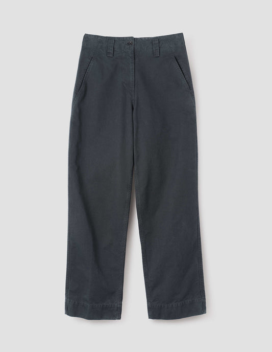 Blue cotton canvas trousers with stitch through waistband, button fastening, dropped belt loops and concealed slant pockets. Front flat lay view. 
