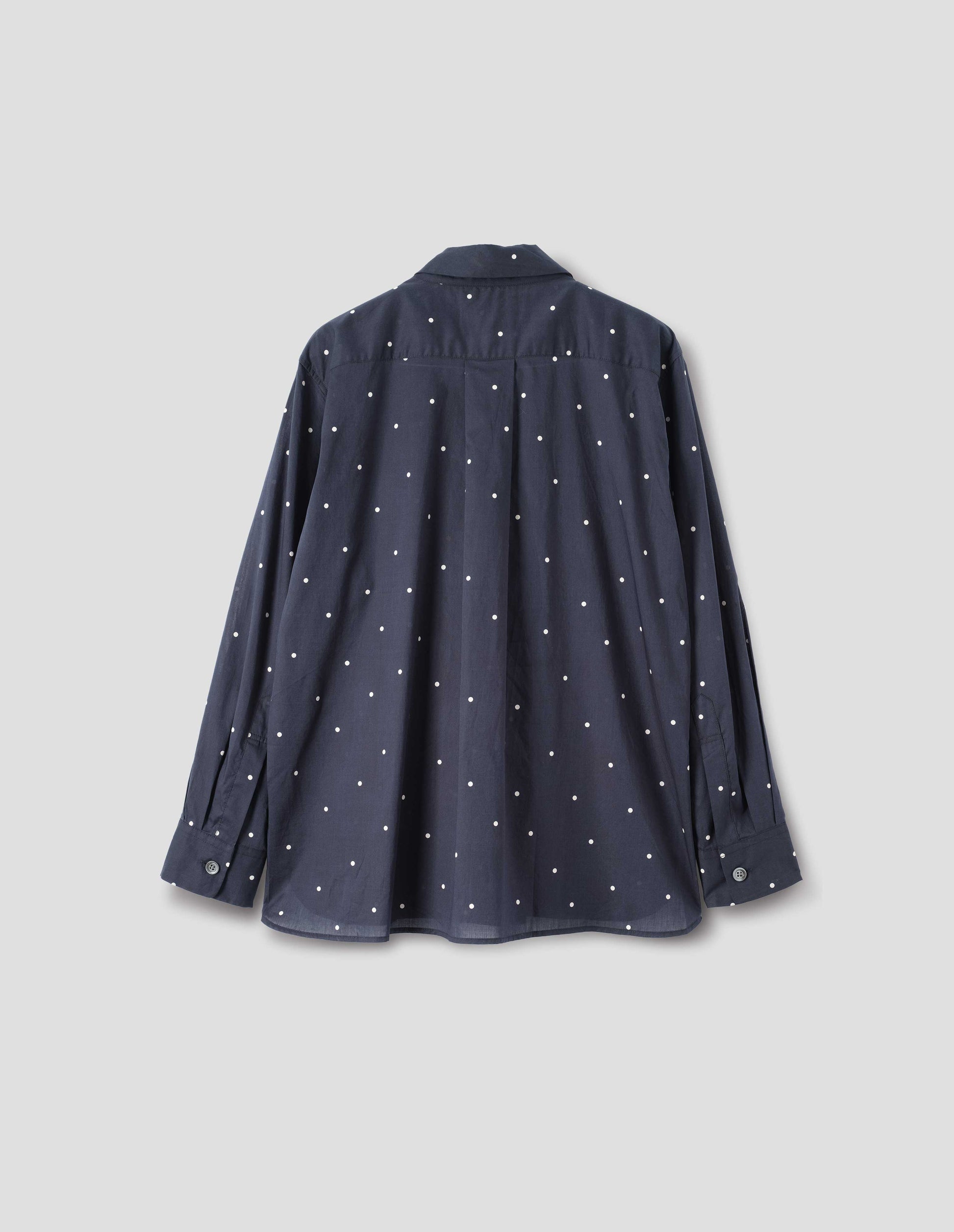 Navy and white polka dot long sleeve shirt with elongated back and removeable self fabric tie. Back flat lay view.