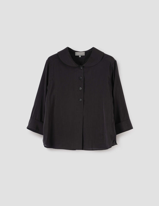 Black petal collar shirt with three quarter length sleeves, stitch through half placket, mother of pearl buttons and turned back cuff details. Front flat lay view.
