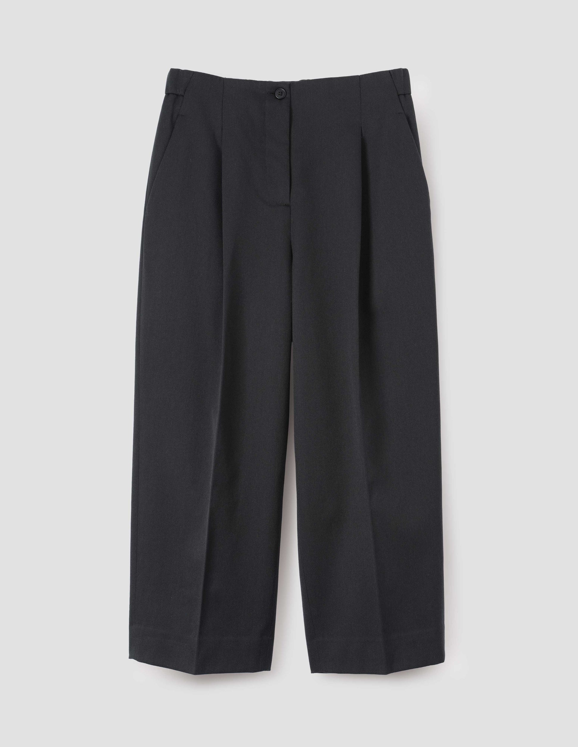Dark grey trousers with zip and horn button fastening, pleats and side pockets, front flat lay view.